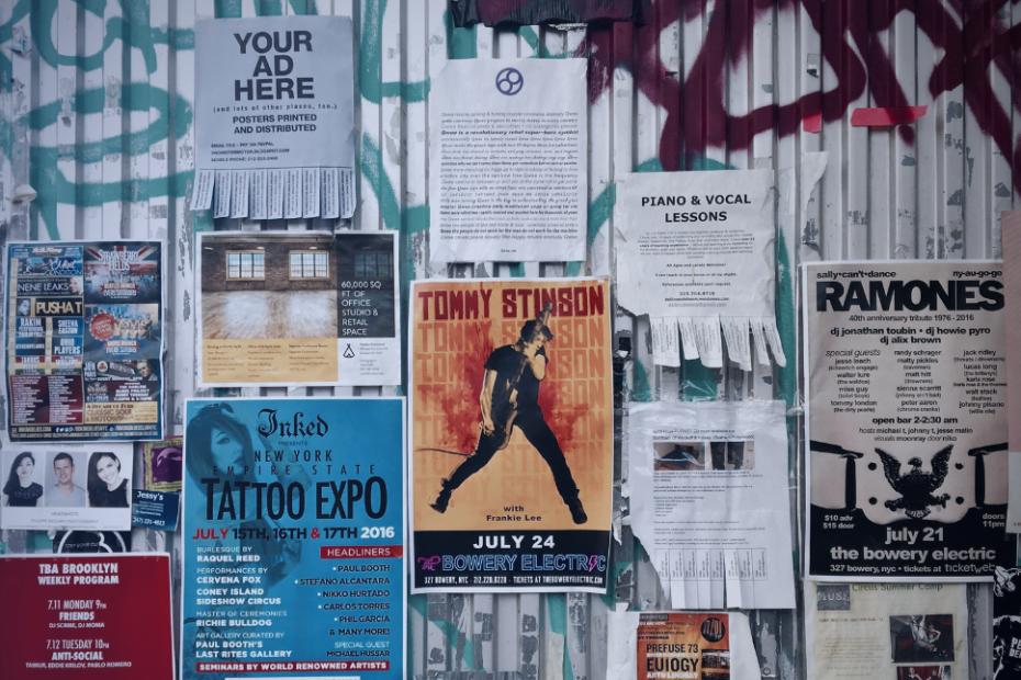 Muro con carteles publicitarios y anuncios urbanos que representan la competencia en publicidad y marketing digital.