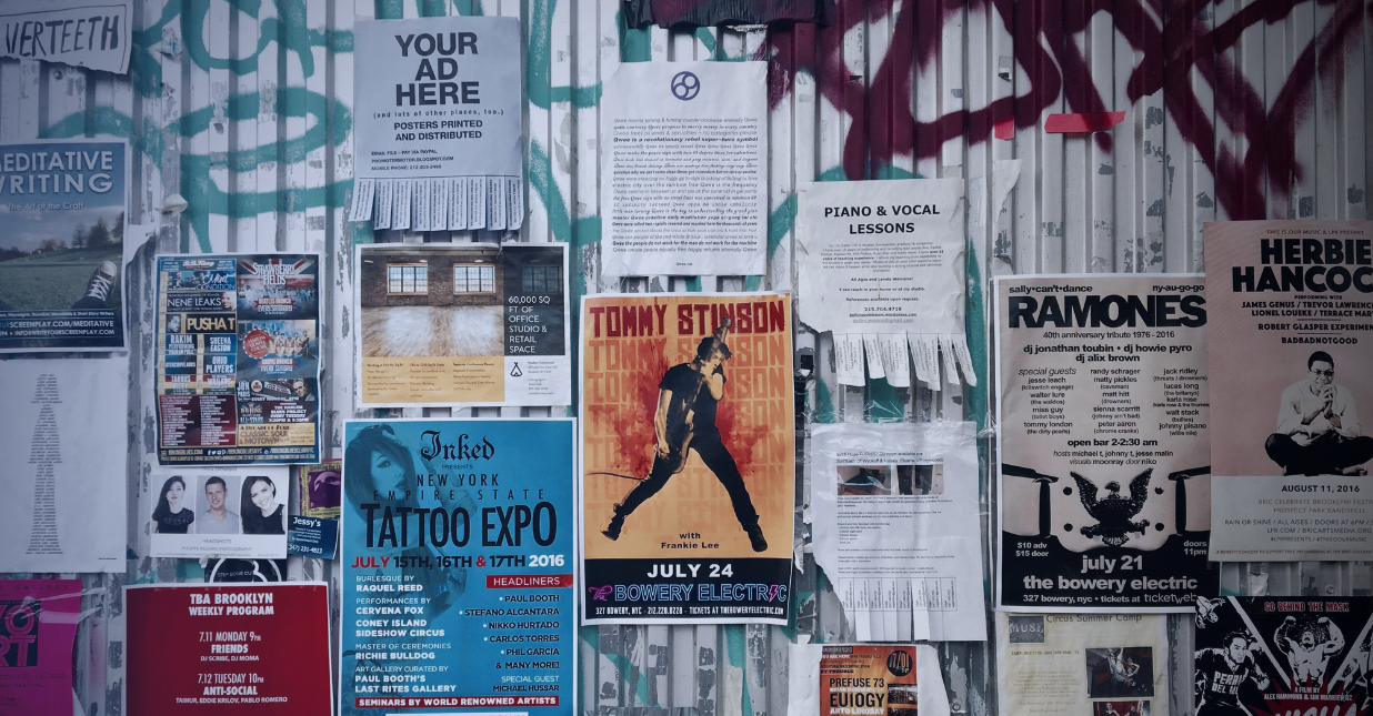 Muro con carteles publicitarios y anuncios urbanos que representan la competencia en publicidad y marketing digital.